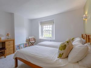 a bedroom with a white bed and a window at Middle Cottage in Easton on the Hill