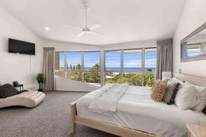 a bedroom with a large bed and a large window at Andari Holiday Apartments in Sunshine Beach