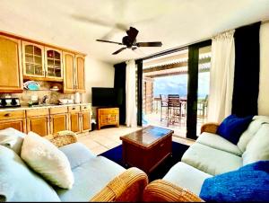 a living room with a couch and a table and a kitchen at Sapphire Beach-Beachfront Condo SALE - View of Paradise in East End