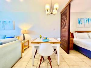 een kamer met een tafel en een bed en een slaapkamer bij Sapphire Beach-Beachfront Condo SALE - View of Paradise in East End