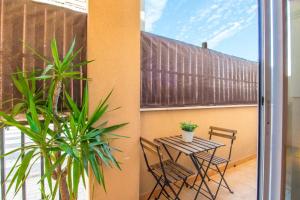 patio con mesa y sillas en el balcón en Altorreal Más que apartamentos, en Murcia
