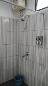uma casa de banho com um chuveiro com um balde azul em PUNCAK VILLAGE HOTEL & KAMPUNG MAIN ANAK em Gadok 1