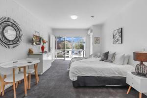 1 dormitorio con cama, escritorio y mesa en Geelong CBD Accommodation, en Geelong