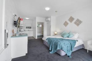 a bedroom with a bed with a blue blanket on it at Geelong CBD Accommodation in Geelong