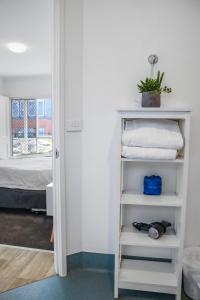 Habitación con estante blanco con toallas en Geelong CBD Accommodation, en Geelong