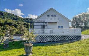 una casa blanca con porche en una colina en Cozy Home In Etne With Wifi en Etnesjøen