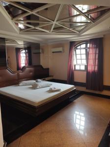 a bedroom with a large bed in a room with windows at Champion motel in Rio de Janeiro