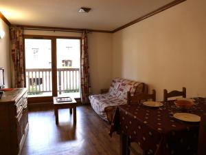 a living room with a table and a couch at Appartement Aussois, 2 pièces, 6 personnes - FR-1-508-280 in Aussois