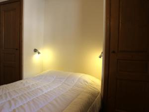 a bedroom with a white bed with lights on it at Appartement Aussois, 2 pièces, 6 personnes - FR-1-508-280 in Aussois