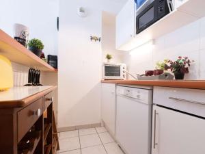 a kitchen with white cabinets and a microwave at Maison Saint-Lary-Soulan, 3 pièces, 4 personnes - FR-1-296-437 in Saint-Lary-Soulan