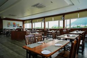 a dining room with tables and chairs and windows at HOTEL SUNRISE HOSPITALITY in Vijayawāda