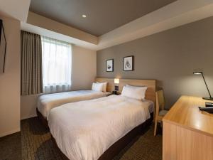 a hotel room with two beds and a desk at Best Western Hotel Fino Tokyo Akihabara in Tokyo