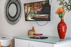 a counter with two vases and a tv on a wall at Geelong CBD Accommodation in Geelong