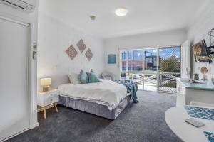 a bedroom with a bed and a large window at Mibnb Geelong CBD Spacious Studio Apartments in Geelong