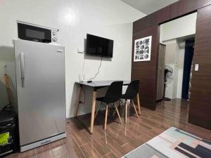 a dining room with a table and a refrigerator at Air Residences - 1Bedroom Unit with Balcony - Wifi & Netflix in Manila