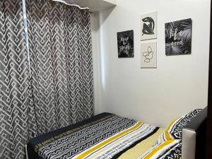 - une chambre avec un lit et un rideau noir et blanc dans l'établissement Air Residences - 1Bedroom Unit with Balcony - Wifi & Netflix, à Manille