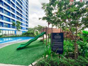 a playground with a slide next to a swimming pool at Air Residences - 1Bedroom Unit with Balcony - Wifi & Netflix in Manila