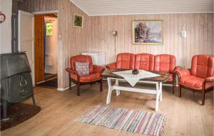 een woonkamer met rode stoelen en een tafel en een televisie bij 3 Bedroom Awesome Home In Vikersund in Vikersund