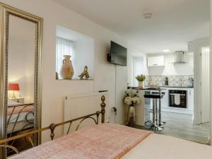 a bedroom with a bed and a mirror and a kitchen at Orchard View-uk34417 in Cheddar