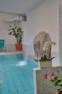 una piscina con una fuente de agua en un edificio en Hotel Terme Villa Teresa, en Isquia