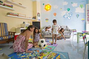 uma mulher e três crianças numa sala com uma bola de futebol em Hotel Terme Villa Teresa em Ischia