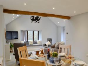 a living room with a table and chairs at Cwm Dulas in Llanddewi-Brefi