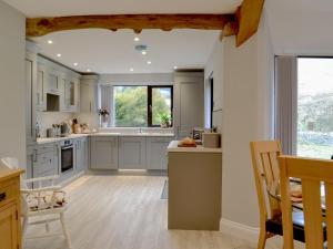 a kitchen with white cabinets and a large window at Cwm Dulas in Llanddewi-Brefi