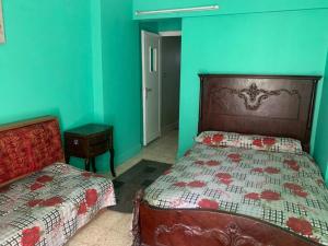 1 dormitorio con 2 camas y pared azul en شقة مصيف قريبة للبحر في ميامي en Alexandria