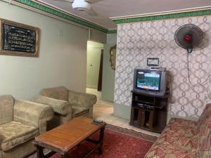 uma sala de estar com um sofá e uma televisão em شقة مصيف قريبة للبحر في ميامي em Alexandria