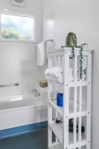 a bathroom with a white shelf next to a bath tub at Geelong CBD Accommodation in Geelong