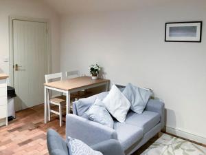 a living room with a couch and a table at Bramble Cottage in Ingoldisthorpe