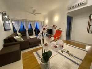 a living room with a couch and a vase with flowers at The View Feringghi Executive Apartment in Batu Ferringhi