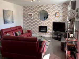 sala de estar con sofá rojo y chimenea en No 2 Railway Cuttings - Uk3402 en Falstone
