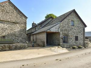 an old stone building with a garage and a street at Stabal Rhoswen in Ffestiniog