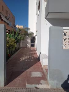 a narrow alley with a white building and plants at Bloque de Viviendas in Ibiza Town