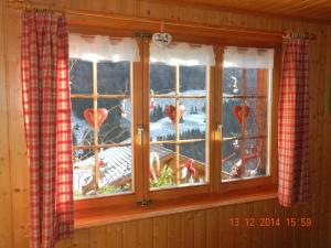 ein Fenster in einer Hütte mit Blick auf einen Hof in der Unterkunft Waldruhe in Jaun