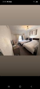 una camera con due letti e un tavolo con una bedsenalsenalsenalsenalangering di Ardhill House The Diamond, in the Heart of Ardara Town , F94 C7X9 a Ardara