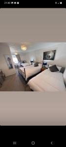 a bedroom with two beds and a room with two chairs at Ardhill House B&B The Diamond, in the Heart of Ardara Town , F94 C7X9 in Ardara