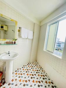 uma casa de banho com um lavatório e uma janela em EVA Hotel em Hue