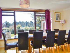 a dining room with a table and chairs and a large window at Kinvara in Stranraer