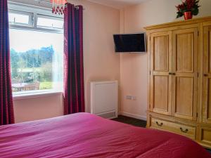 a bedroom with a bed and a window and a dresser at Kinvara in Stranraer