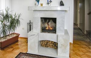 a stone fireplace in a living room with a fire at Holiday Home Dzwierzuty Saplaty Iii in Dźwierzuty