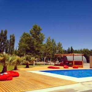 una piscina con terraza de madera y cenador en La Vicuñita Hotel & Cabañas en Rodeo