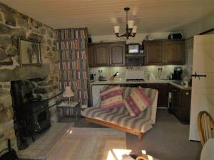 a living room with a couch and a stone fireplace at Tigh Na Maraiche in Craighouse