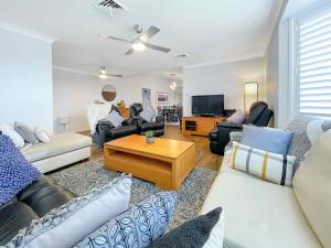 a living room with couches and a tv at Nottage Cottage in Branxton