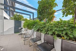 un patio avec des chaises et des plantes dans un bâtiment dans l'établissement Great located unit/Private Balcony, Pool,Gym,Parking, à Brisbane