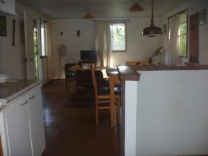 cocina y sala de estar con mesa y sillas en Cabañas Varua, en Hanga Roa