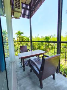 un patio con tavolo e sedie in legno sul balcone. di Nha Bong Villa a Hoi An
