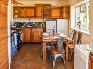 a kitchen with a wooden table with chairs and appliances at Valley View in Upper Arley