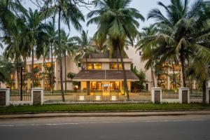 un edificio con palmeras delante en Silver Waves Resort & Spa Daman, a member of Radisson Individuals en Daman